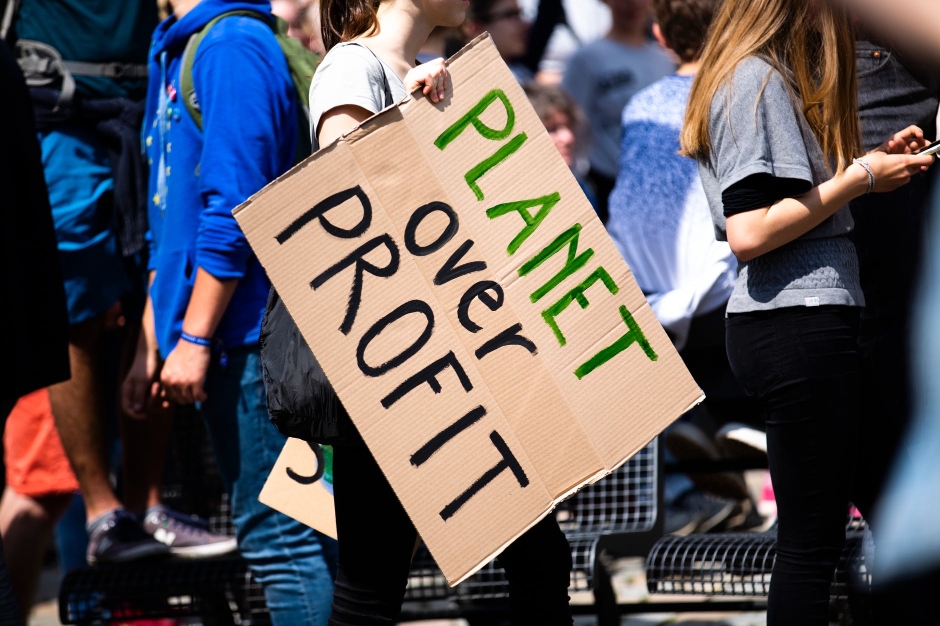 women holding a planet over profit sign